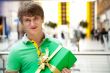 Portrait of young man inside shopping mall with gift box sitting