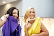 Group of two beautiful shopping women trying on clothes at shopp