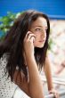 Portrait of young pretty woman talking with someone using cell p