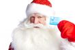 Traditional Santa Claus holding and sowing credit card while giv