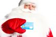 Traditional Santa Claus holding and sowing credit card while giv