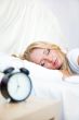 Woman sleeping in bed and alarm-clock 