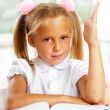 Portrait of a young girl in school at the desk.