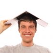 Portrait of young man holding his laptop on his head like roof o