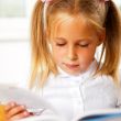 Image of smart child reading interesting book in classroom