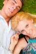 A happy young couple lying on grass