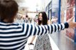 Young man meeting his girlfriend with opened arms at airport arr
