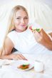 Woman having breakfast in bed. Healthy continental breakfast. Ca