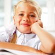 Portrait of a young girl in school at the desk.