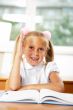 Portrait of a young girl in school at the desk.