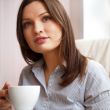 Young woman at home sipping tea from a cup