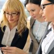 Closeup portrait of three women working indoor together with doc