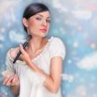 Portrait of a Beautiful woman applying makeup with brush on her 
