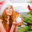 Christmas woman near a Christmas tree holding Christmas toy whil