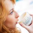 Portrait of beautiful red hair girl drinking coffee on winter ba