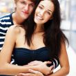 Portrait of young couple embracing at shopping mall and looking 