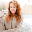 Portrait of beautiful red hair girl drinking coffee on winter ba