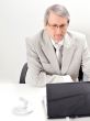 Portrait of an older businessman with a computer and a cup.