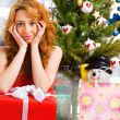 Christmas woman near a Christmas tree holding big gift box while