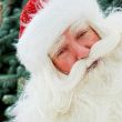 Portrait of Santa Claus standing with hand on chin outdoors at c