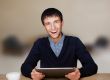 Closeup of a young smiling business man sitting at his living ro