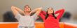 Smiling beautiful couple sitting on a sofa at their apartment an