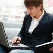 Portrait of handsome young man working with laptop at cafe at bu