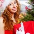 Christmas woman near a Christmas tree holding big gift box while