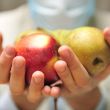 Doctor holding fresh fruits in his arms
