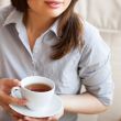 Young woman at home sipping tea from a cup