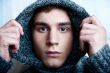 Portrait of young handsome man putting on warm pullover and look