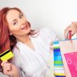 Beautiful shopping woman holding bags and credit card at a mall 