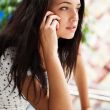 Portrait of young pretty woman talking with someone using cell p