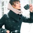 Portrait of young beautiful woman standing alone in winter park 