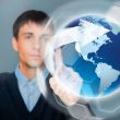 Portrait of handsome young man touching virtual globe. Global ne