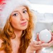 Christmas woman near a Christmas tree holding Christmas toy whil