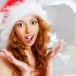 Christmas woman near a Christmas tree very excited while sitting