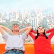 Closeup portrait of adult couple sitting on their sofa against b