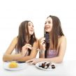 Two women whispering and smiling