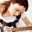 Portrait of beautiful young and attractive womanplaying her guit