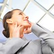 Portrait of beautiful business woman on the phone at modern buil