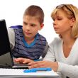 Portrait of adult woman watching as her son doing homework