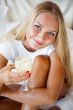 Woman drinking fresh ice tea beverage and looking at camera whil