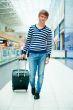 Portrait of a successful young man walking with travel bag at mo