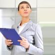 Portrait if young business woman at her office holding report