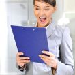 Portrait if young business woman at her office holding report