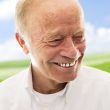 Portrait of a happy senior man smiling over bright background