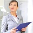Portrait if young business woman at her office holding report