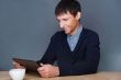 Closeup of a young smiling business man sitting at his office ag