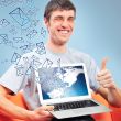 Portrait of handsome young man holding laptop computer and worki